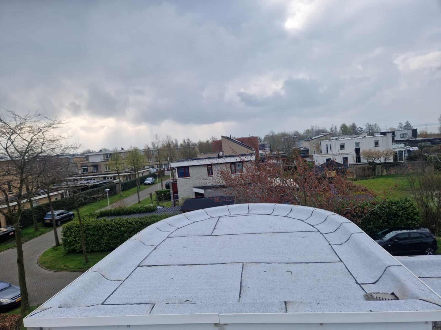 Plat dak nieuw gedekt met witte bitumen dakbedekking in woonwijk
