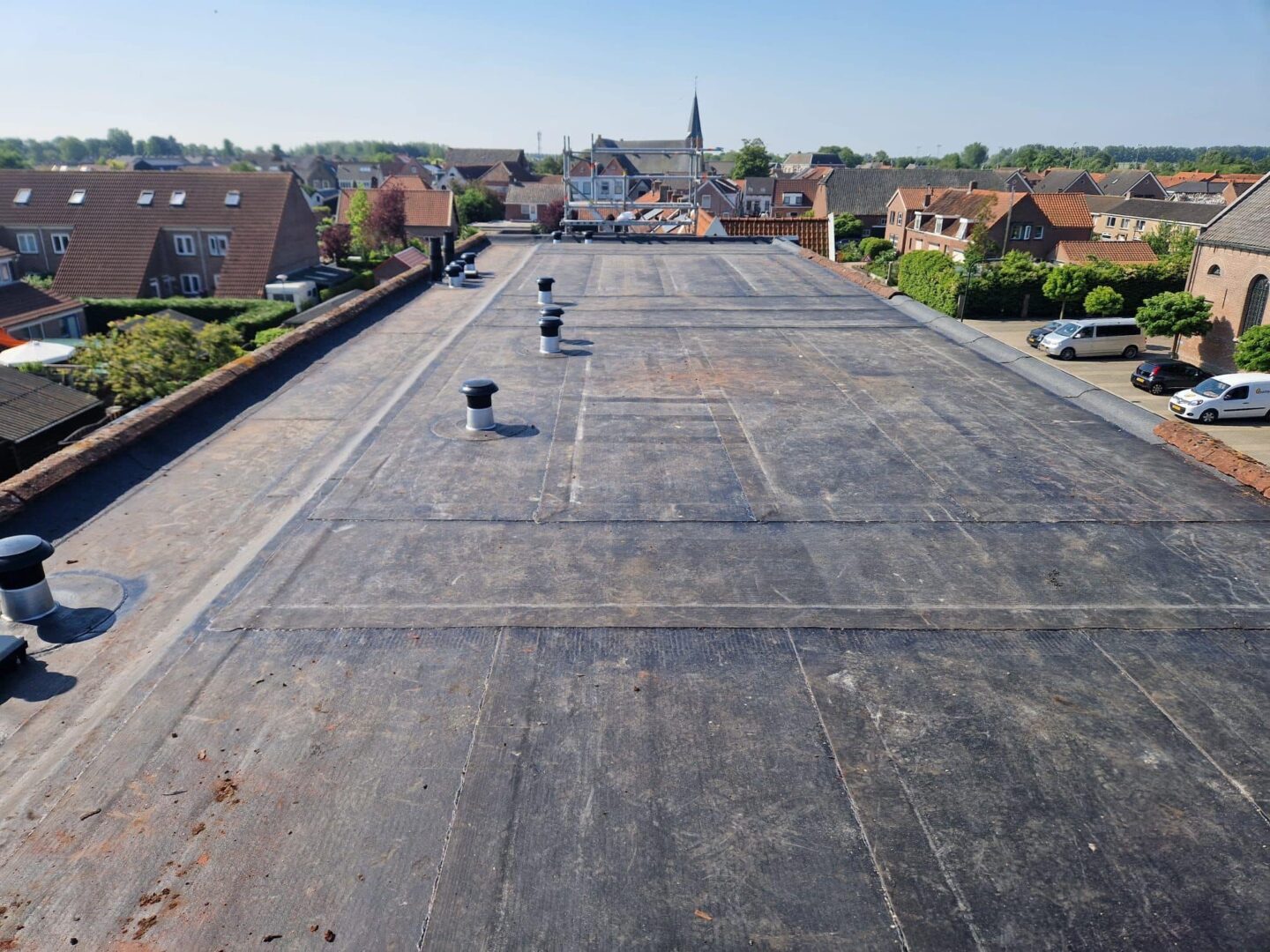 Plat dak met EPDM-bedekking en ventilatiepijpen in Nederlandse woonwijk